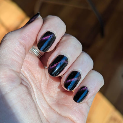 A finished manicure with vibrant, sharp magnetic cat-eye lines on all nails, achieved using a hands-free 5-finger magnetic nail tool.