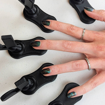 Top-down view of a hand with five fingers resting in individual magnetic tool bases, showing the complete setup for efficient cat-eye polish results.