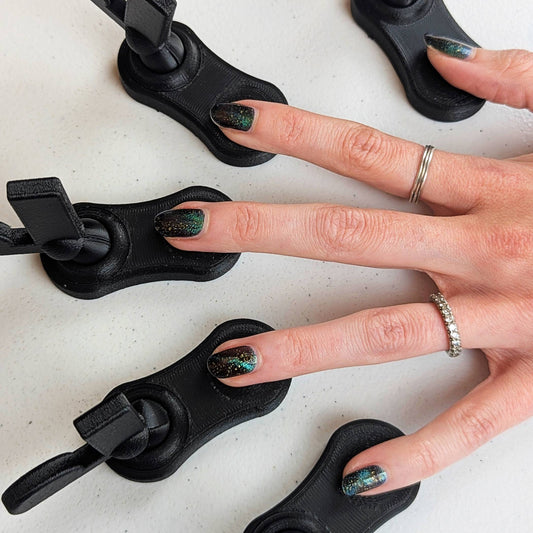 Top-down view of a hand with five fingers resting in individual magnetic tool bases, showing the complete setup for efficient cat-eye polish results.